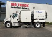 Side view of a white sweeper truck