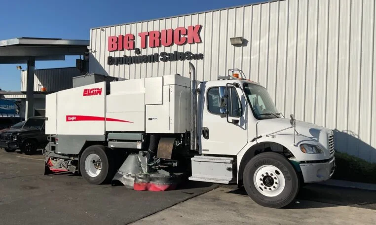 a white 2017 Freightliner M2 Elgin Eagle Waterless Street Sweeper parked outside