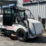 2019 Elgin Pelican CNG street sweeper operating on a city roadway.