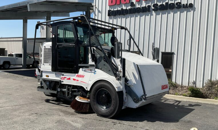 2019 Elgin Pelican CNG street sweeper operating on a city roadway.