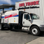 White VacMasters System 5000 truck parked in front of a Big Truck & Equipment Sales building.